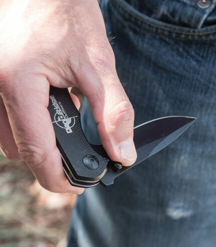 Black anodized tactical diamond knife engraved with logo being held