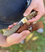 maple burlwood fixed blade engraved with logo beside sheath