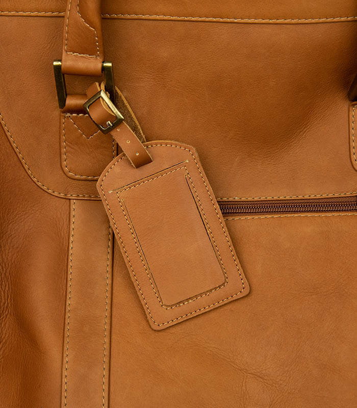 Leather luggage tag on leather duffle bag
