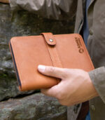 Man holding small leather snap journal