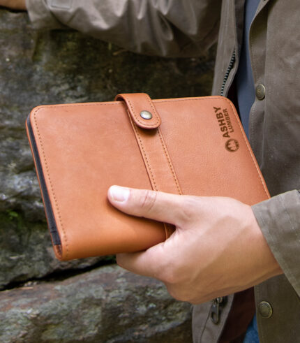 Man holding small leather snap journal